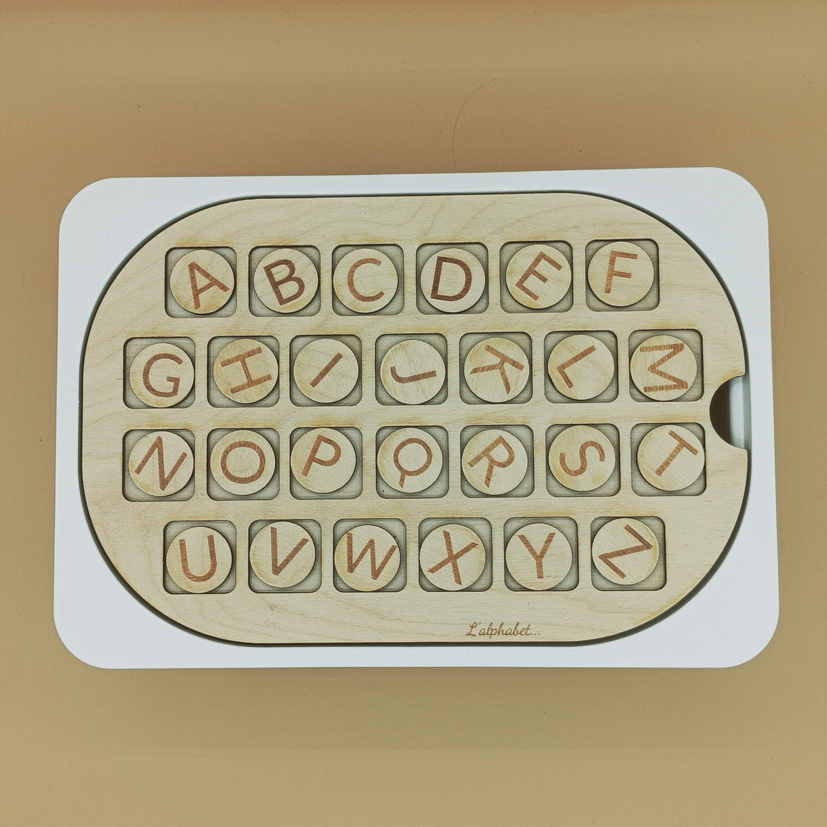 Enfant manipulant l’Insert apprentissage Alphabet, apprentissage ludique et inclusif.